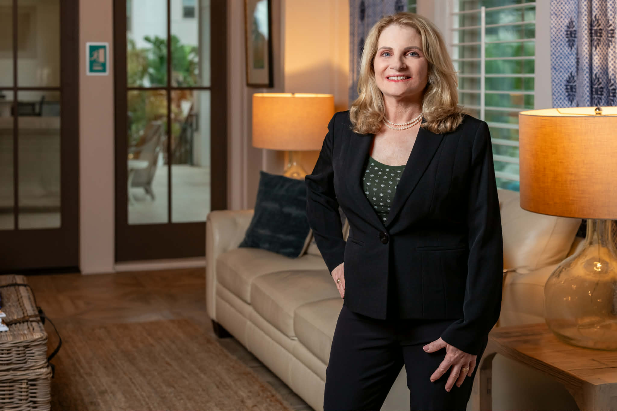 Professional home stager headshot in beautifully staged living room with elegant coastal decor