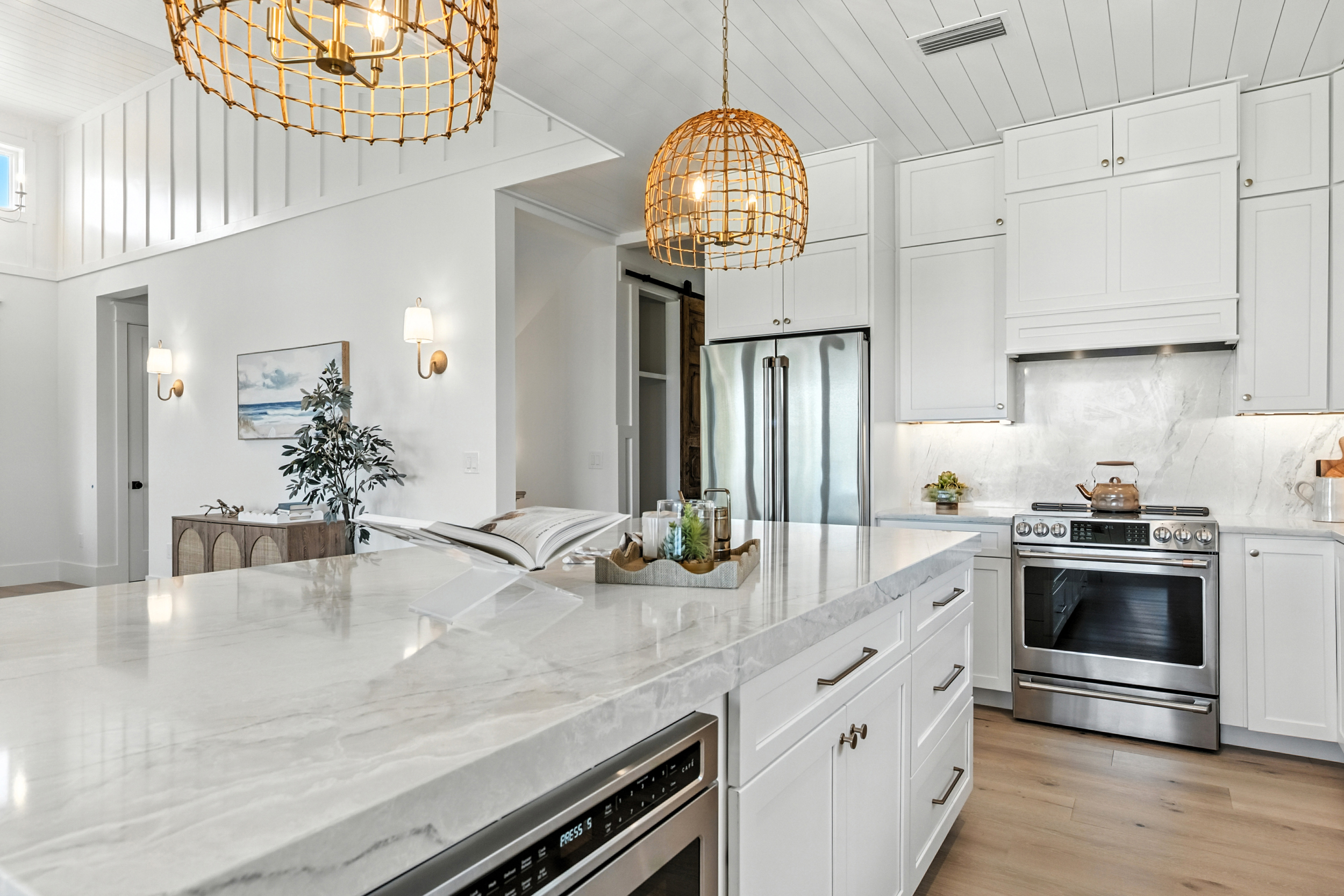 Stunning coastal kitchen with marble island and rattan globe pendants